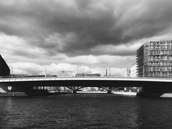 Bridge over river against cloudy sky