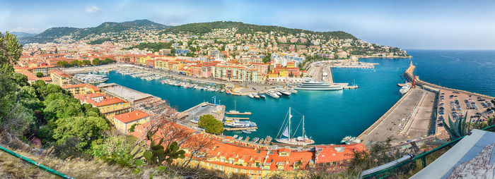 Aerial view of townscape by sea against sky