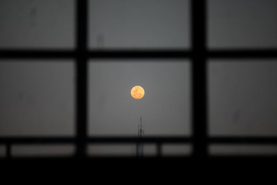 Yellow moon in sky seen from window