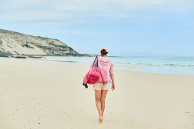 Rear view of woman walking on beach