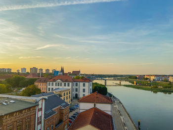 High angle view of buildings by river against sky