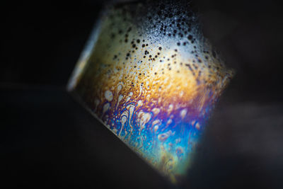 Close-up of bubbles on table against black background