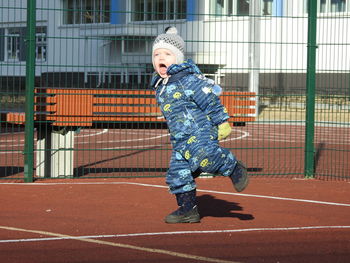 Full length of boy running on fence