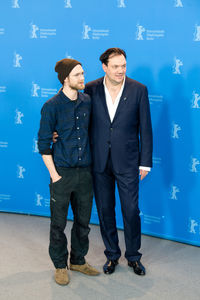 Young couple standing against blue wall