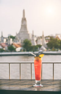 Close-up of drink against sky at sunset