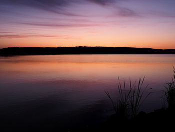 Scenic view of lake against romantic sky at sunset