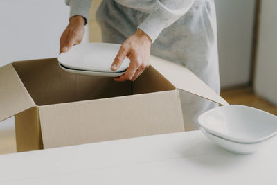 Midsection of woman holding crockeries in new house