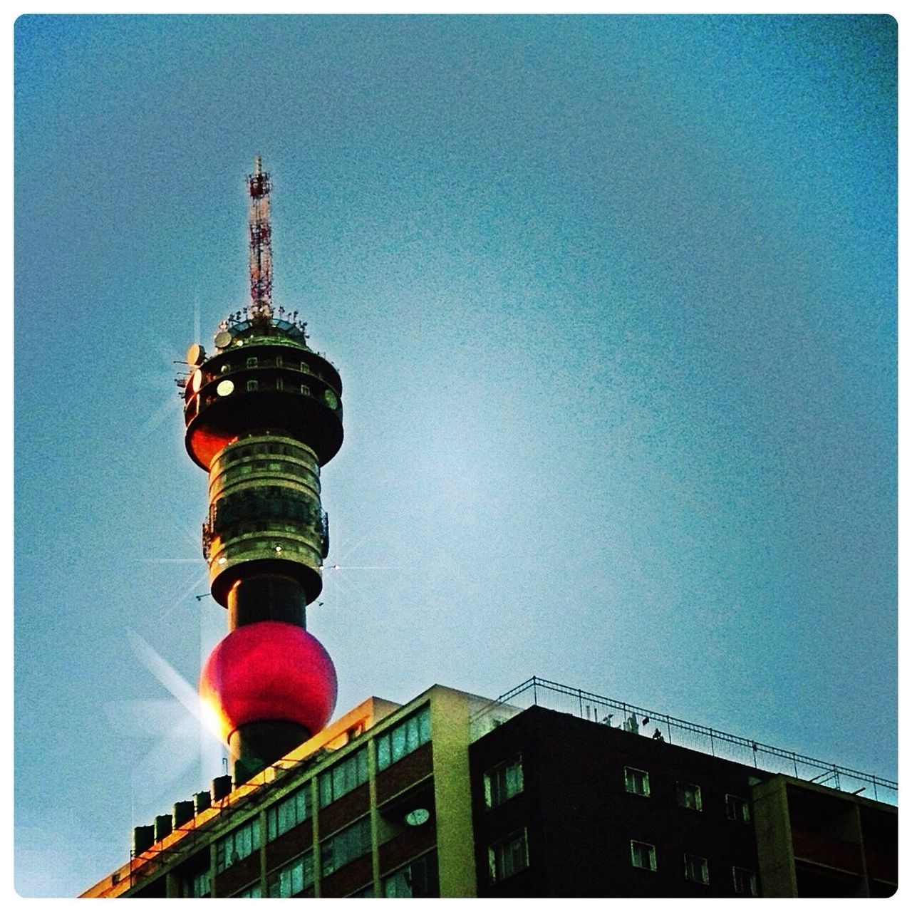 architecture, built structure, building exterior, low angle view, transfer print, auto post production filter, sky, tower, red, blue, city, outdoors, high section, clear sky, building, lighting equipment, guidance, no people, day, dusk