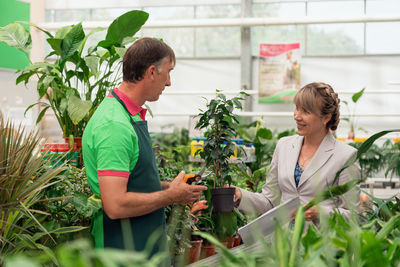 Side view of senior woman gardening in greenhouse