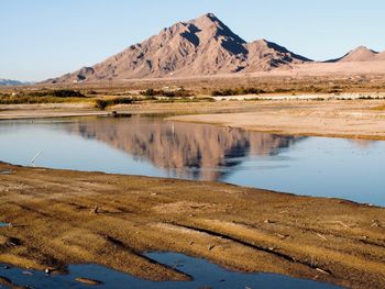 Scenic view of lake by mountains against sky