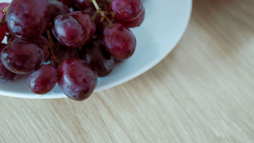 High angle view of grapes in bowl on table