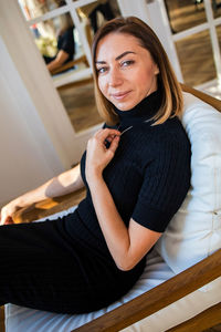 Young woman sitting on sofa at home