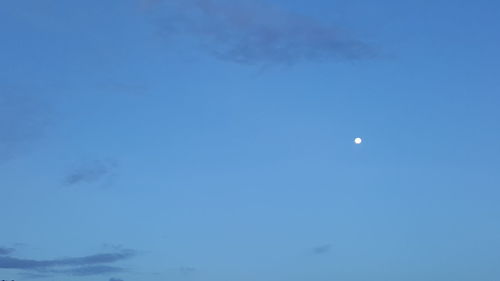 Low angle view of moon in blue sky