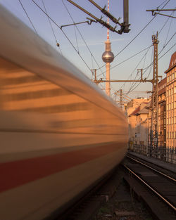 Railroad station platform against sky at sunset