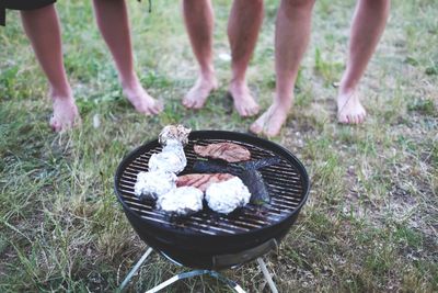 Low section of man standing in front of barbeque grill