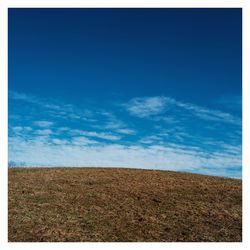 Scenic view of field against blue sky