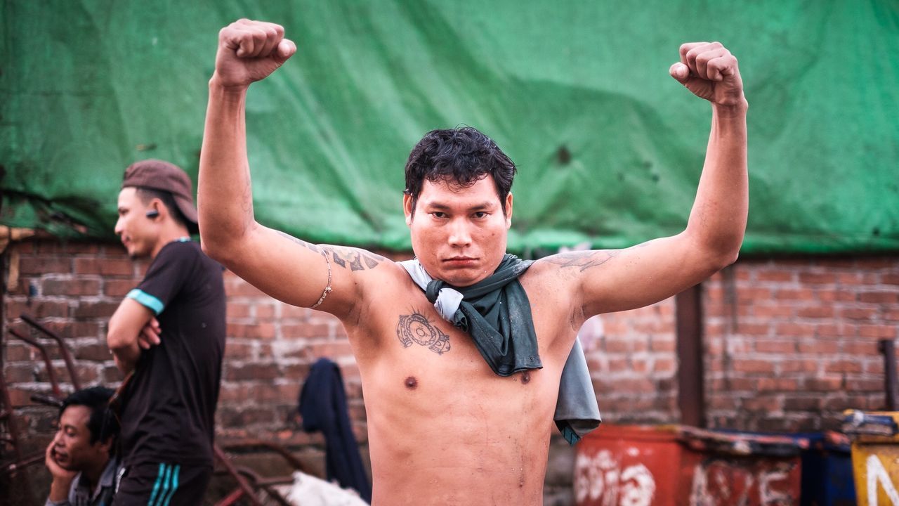 human arm, real people, young adult, limb, arms raised, young men, front view, lifestyles, muscular build, people, sport, human limb, strength, focus on foreground, body part, portrait, human body part, healthy lifestyle, men, effort, brick