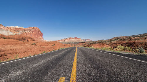 Empty road by mountain against sky