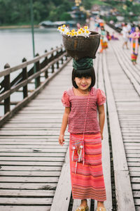 Portrait of a smiling girl standing on footbridge