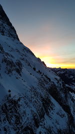 Scenic view of snow covered mountains against sky during sunset