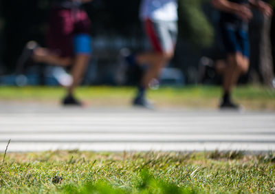 Low section of men running on sports track