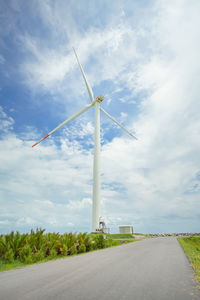 Wind turbines on field against sky