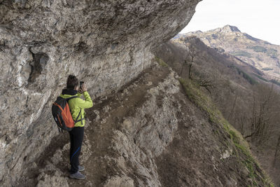 Mountaineer taking photos at the atxuri pass on mount gorbea