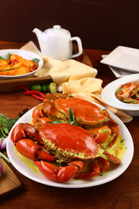 High angle view of red crabs with sauce in plate on table