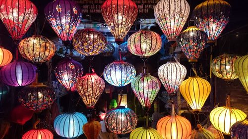 Illuminated lanterns hanging at market stall