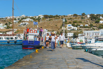 Boats in harbor by sea against clear sky