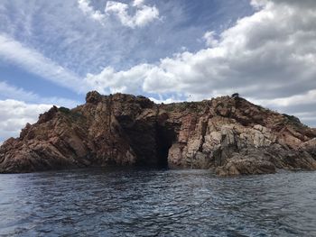 Rock formations by sea against sky