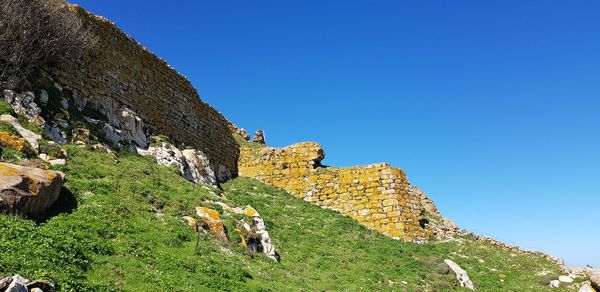 Low angle view of fort against clear blue sky