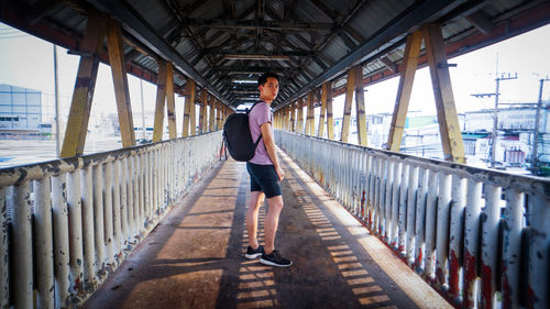 Portrait of man standing on covered bridge