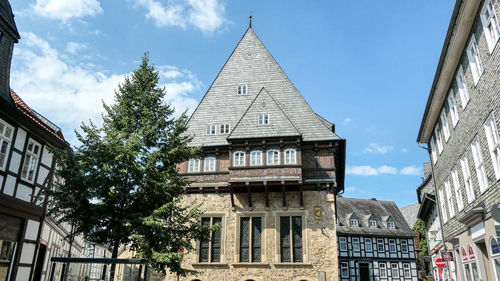 Low angle view of trees and building against sky