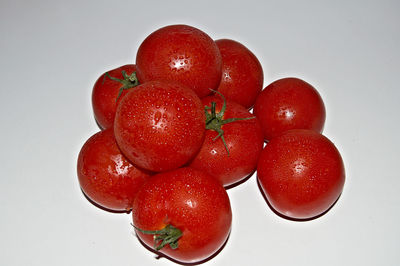 Close-up of wet cherries against white background