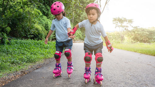 Full length of children on road against plants