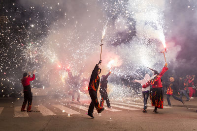 People watching firework display at night