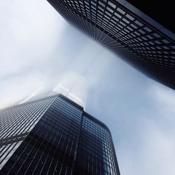 Low angle view of modern building against cloudy sky