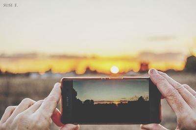 Person photographing at sunset