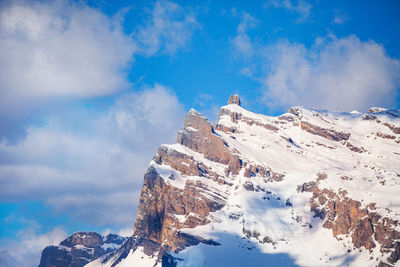 Low angle view of snowcapped mountains against sky