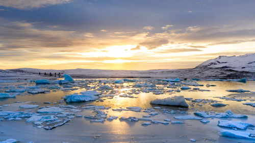 Scenic view of frozen lake against sky during sunset