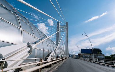 View of white cable bridge against blue sky in city