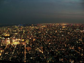 Illuminated cityscape against sky at night