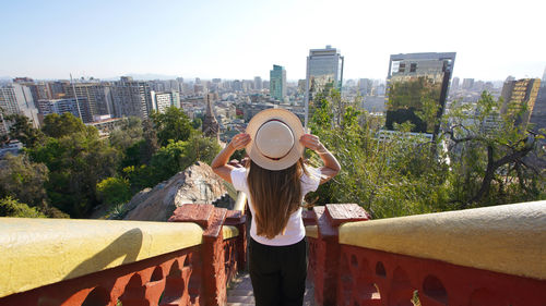 Rear view of woman standing by railing