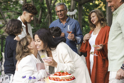 Happy women hugging each other during midsummer dinner party