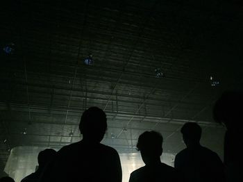 Low angle view of silhouette people standing in corridor