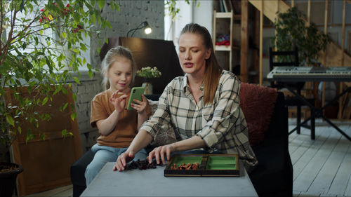 Mother playing chess with daughter