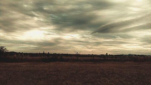 Scenic view of field against cloudy sky