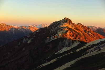 Scenic view of mountains against clear sky during sunset