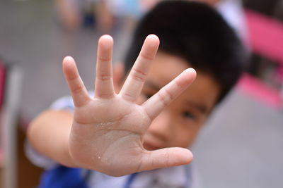 Close-up of boy showing stop gesture